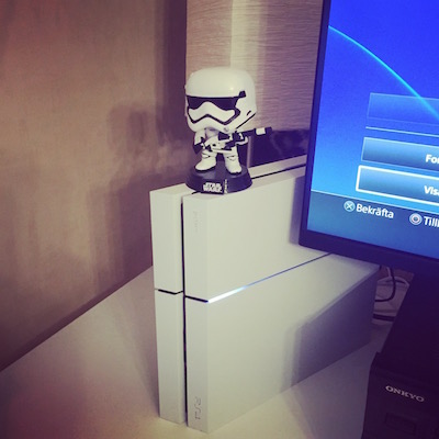 White Playstation 4, with Star wars stormtrooper figure on top
